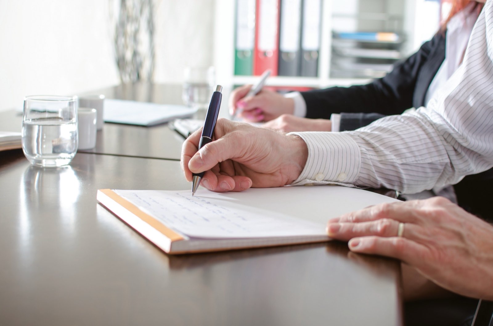 Taking notes at a meeting table