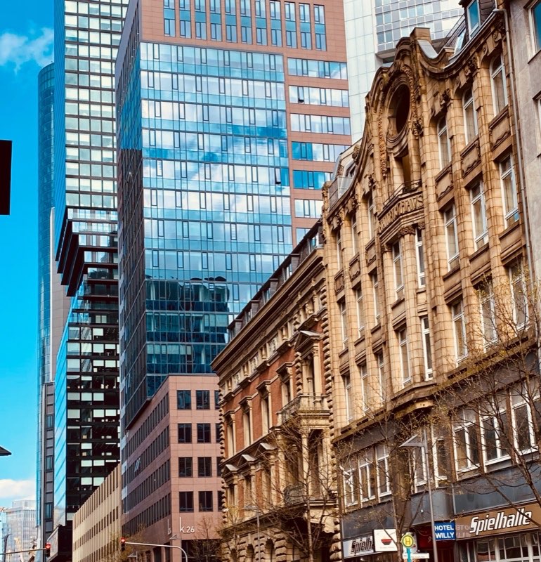 Glass towers behind period facades in a city centre